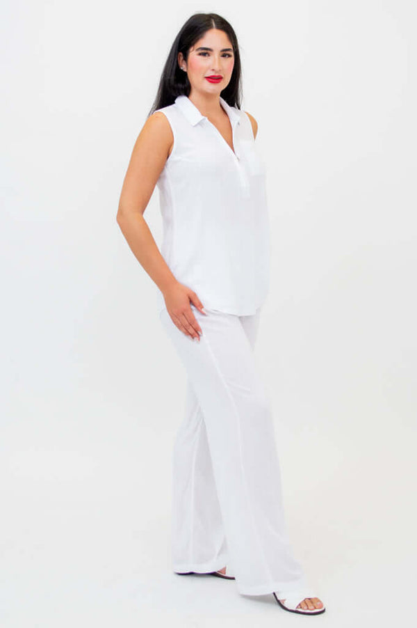 Side view of woman in white quarter-zip tank and wide-leg pants