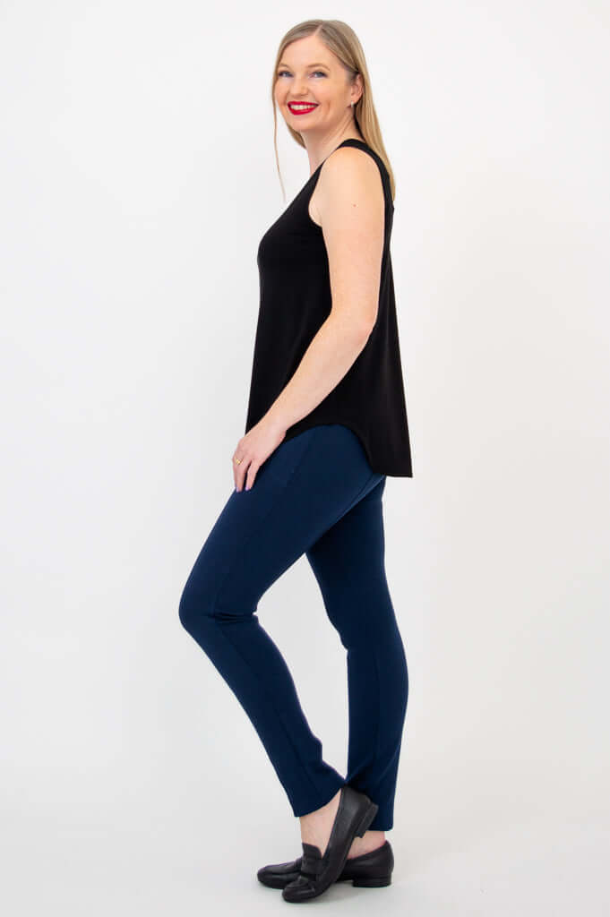 Side view of black bamboo tank top on woman with blue pants