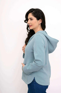Side view of a woman in a light blue hoodie jacket showing the fluid hemline
