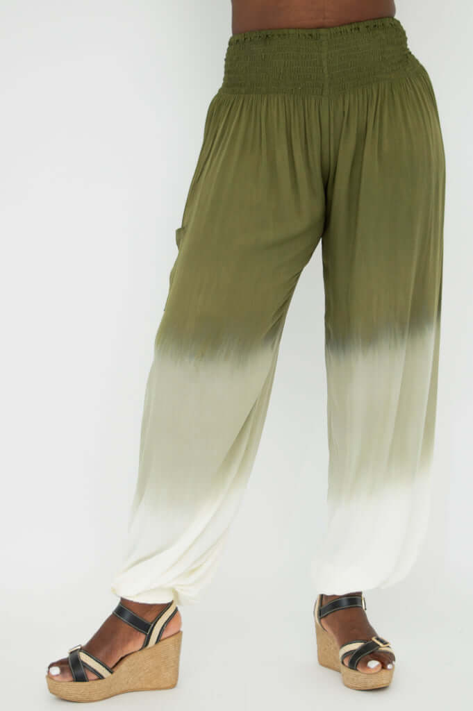 Side angle of ombre pants showing gathered waist and draped leg, model standing in sandals