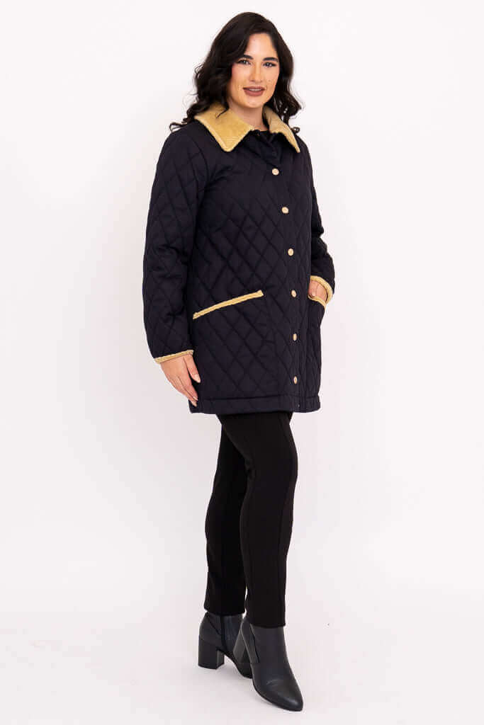 Side view of woman in black quilted coat with hands in pockets