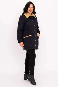 Side view of woman in black quilted coat with hands in pockets