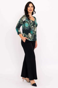 Side view of model in green floral 3/4 sleeve top paired with wide leg black pants