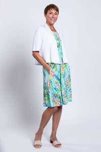 Side view of a blue floral ruched dress styled with a white cardigan