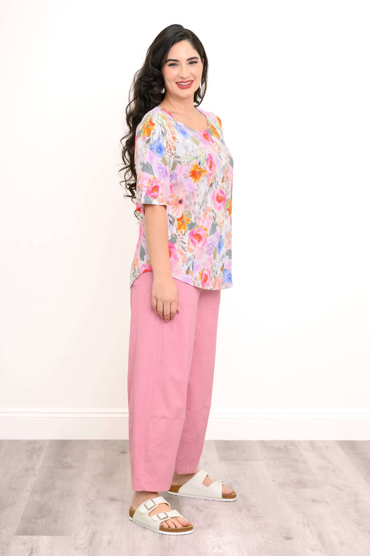 Side view of model wearing the Liza floral blouse with pink pants