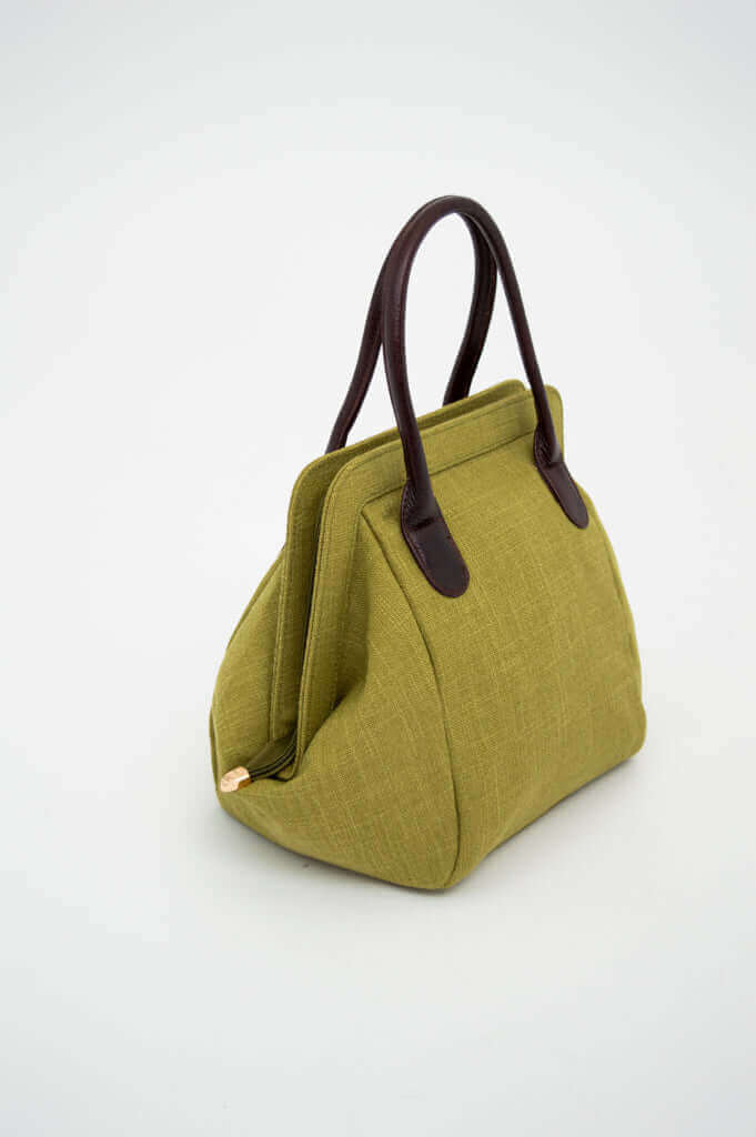 Side view of olive green handbag with dark brown handles on a plain background