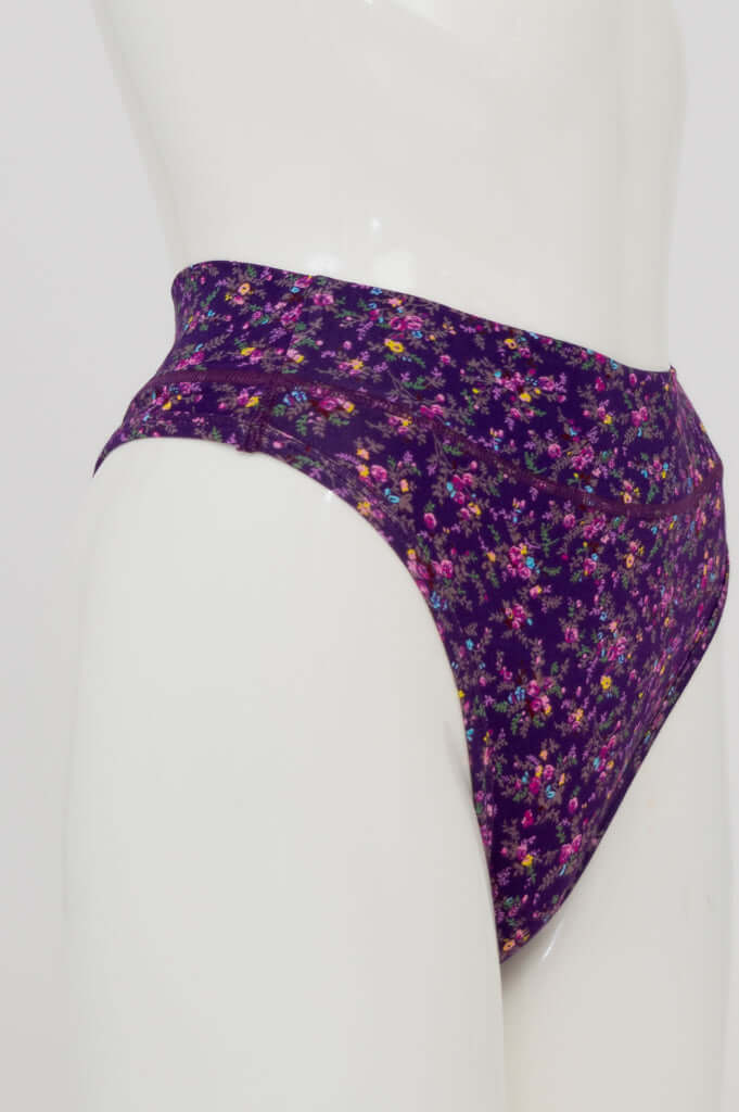 Side view of a purple floral print thong underwear on a mannequin