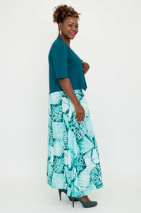 Side view of model in teal cropped bamboo jacket paired with turquoise patterned dress
