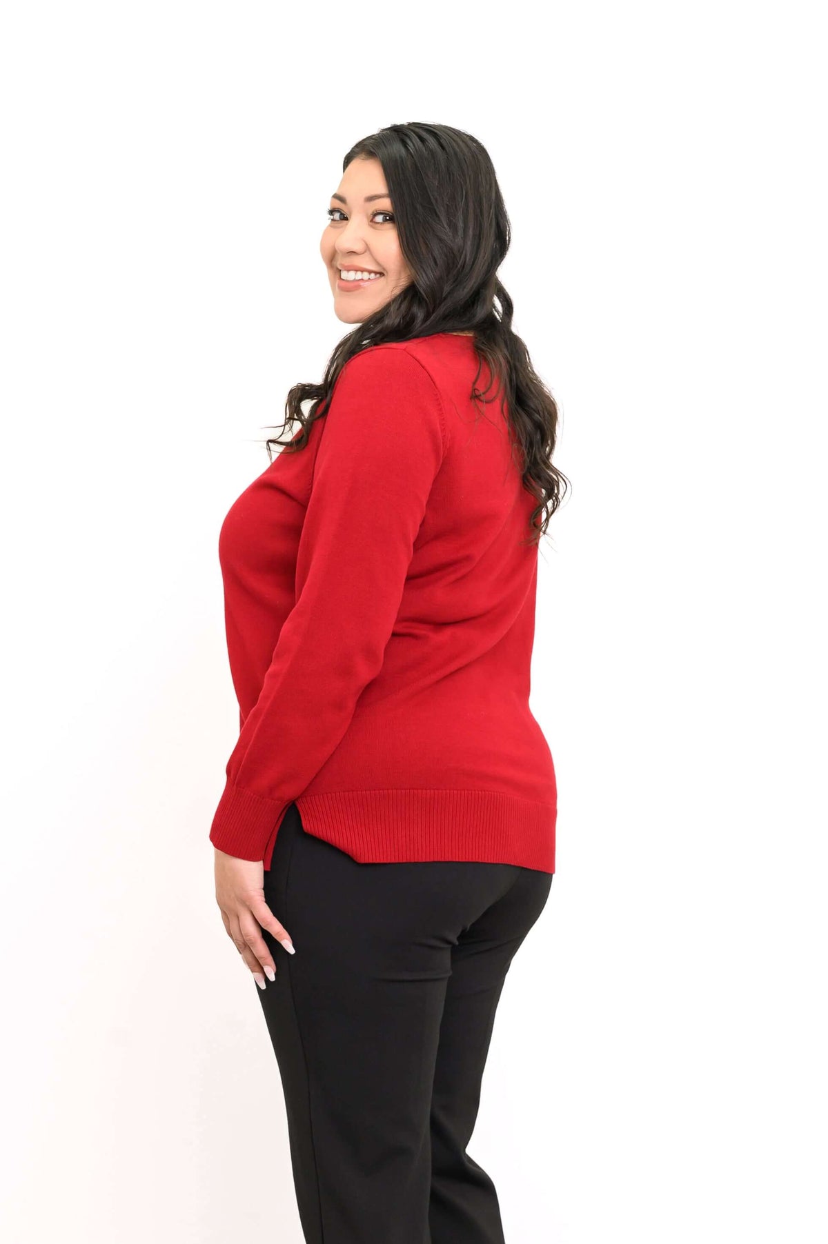 Side view of woman wearing a red V-neck sweater showing side slit
