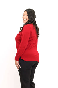 Side view of woman wearing a red V-neck sweater showing side slit