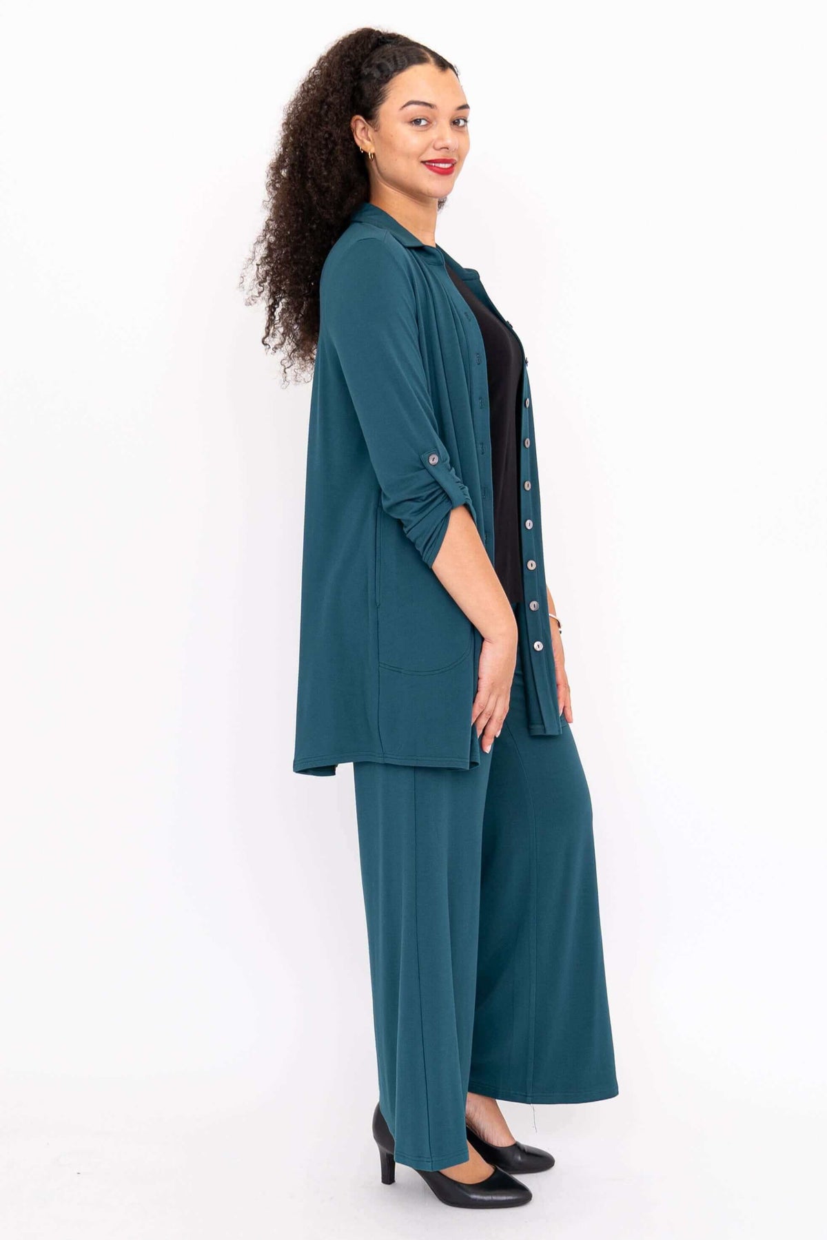 Side view of woman in teal wide leg pants and matching shirt
