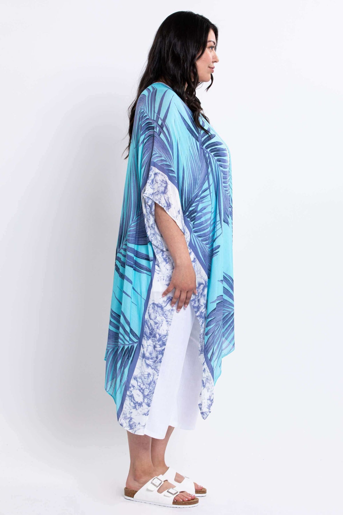 Side view of model wearing a flowing turquoise and blue palm leaf kimono wrap