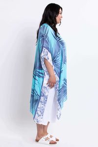 Side view of model wearing a flowing turquoise and blue palm leaf kimono wrap