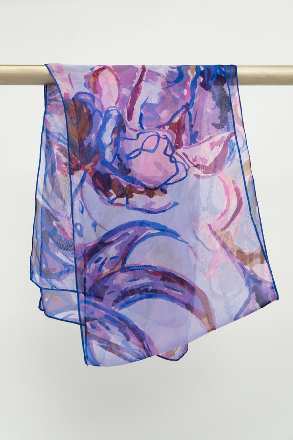 A large silk scarf with a painted floral pattern in shades of purple, displayed on a rod, front view