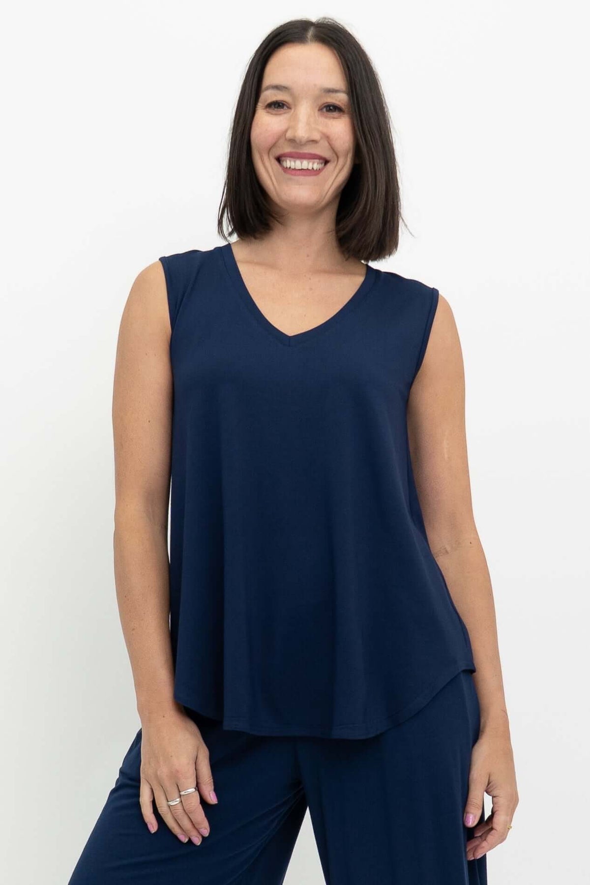 Woman wearing a sleeveless navy blue V-neck top made from bamboo fabric