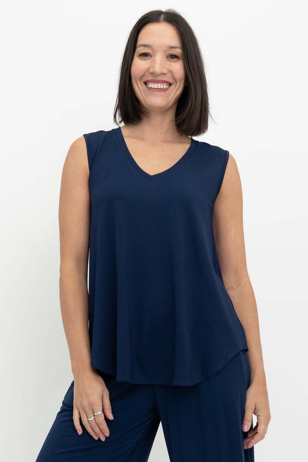 Woman wearing a sleeveless navy blue V-neck top made from bamboo fabric