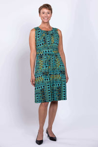Woman wearing a sleeveless turquoise mosaic print dress, front view
