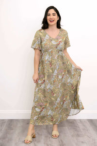 Woman smiling and holding the skirt of green floral Jane maxi dress