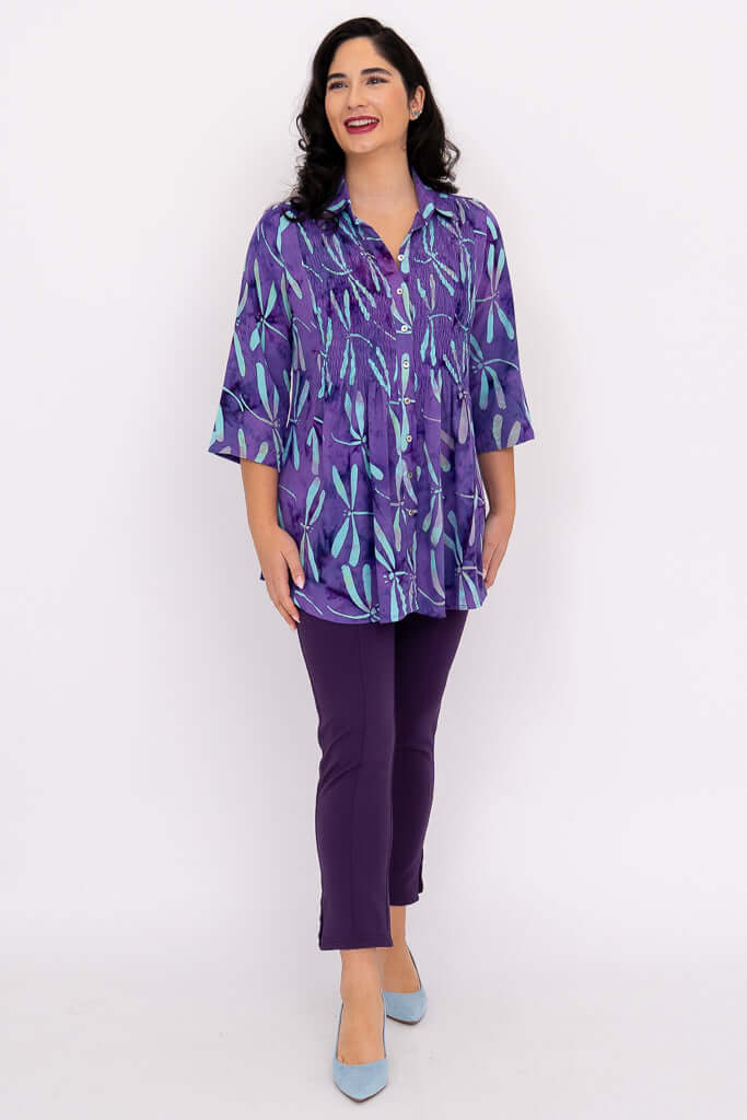 Model smiling in Cindy smocked blouse violet dragonfly print and purple pants, facing forward