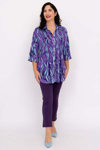 Model smiling in Cindy smocked blouse violet dragonfly print and purple pants, facing forward