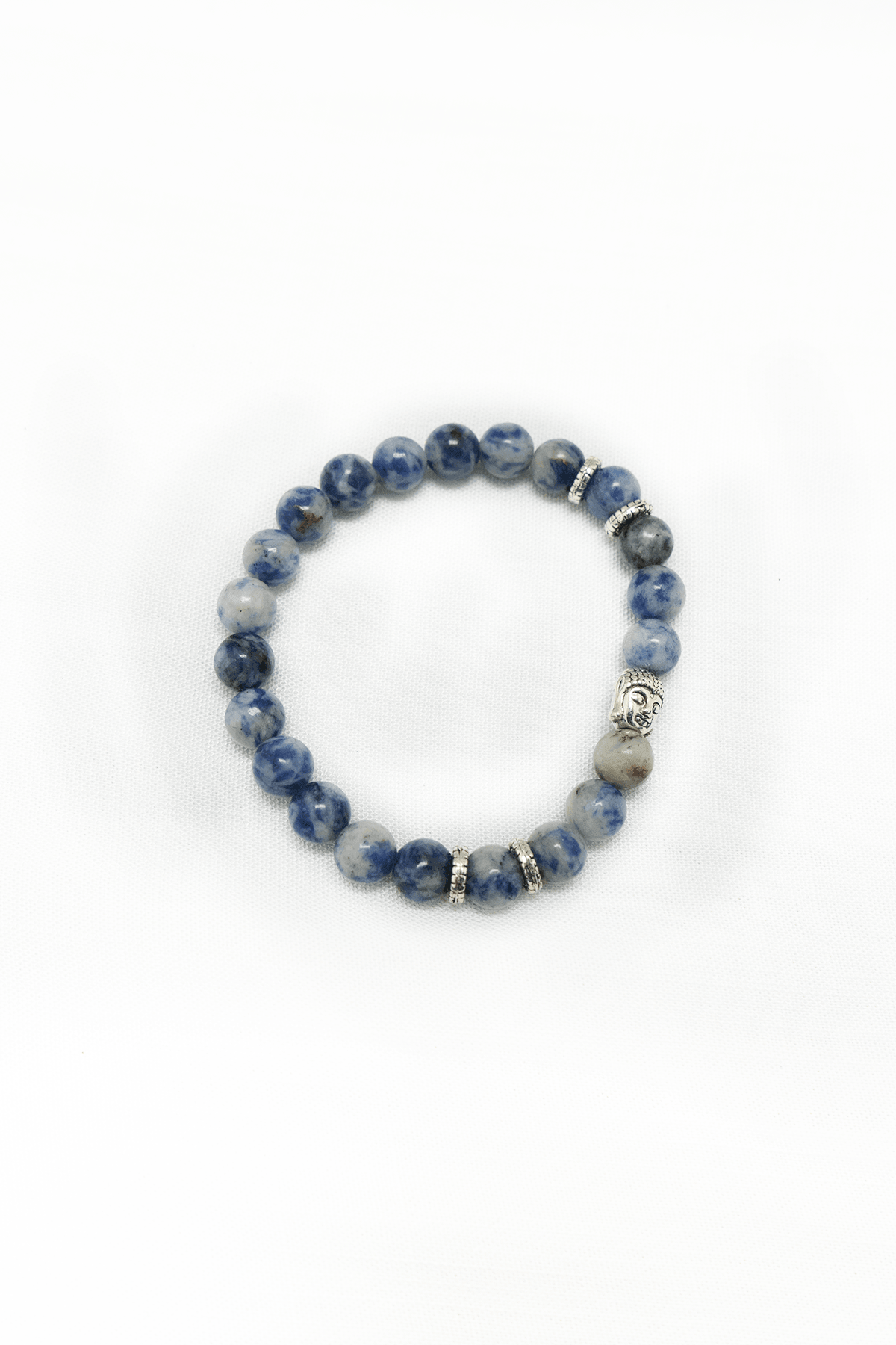 Sodalite bead bracelet with silver accents and Buddha charm on a white background