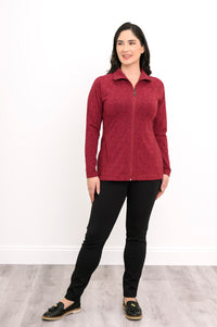 Front view of a women's red geometric print athletic jacket with pockets and a high collar, paired with black pants.