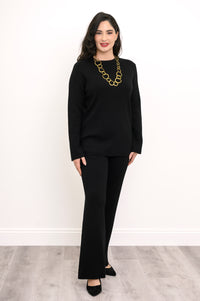 Angled view of an ebony long-sleeve knit top on a model, showcasing a comfortable, body-skimming silhouette.