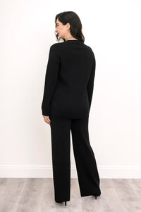 Back view of an onyx knit crew neck sweater, showcasing the clean back panel drape and flat-finish hemline.