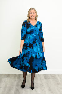 Front view of a woman modeling a blue patterned bamboo cotton midi dress styled with simple black heels.