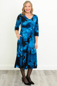 Front view of a woman wearing a blue floral print midi dress with a V-neckline and 3/4 sleeves.