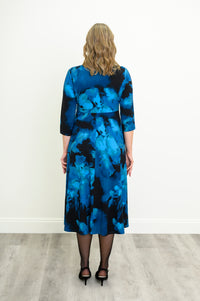 Rear view of an indigo patterned A-line midi dress highlighting the fluid skirt and full coverage.