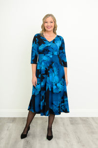 Softly draped blue and black patterned V-neck midi dress, shown from a slight side-angle.