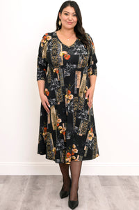 Front view of a woman wearing a black and orange floral midi dress with a V-neckline and 3/4 sleeves.