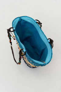 Interior view of blue-lined rattan tote with zippered pocket and braided handles
