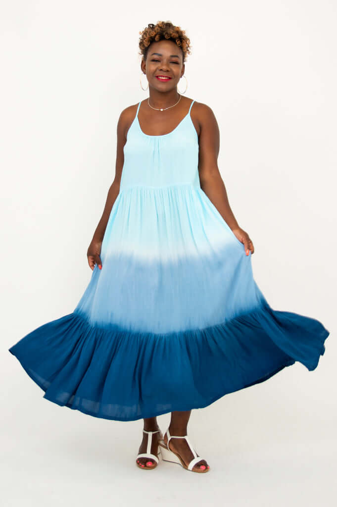 Woman spreading the hem of a blue ombre maxi dress to show fullness
