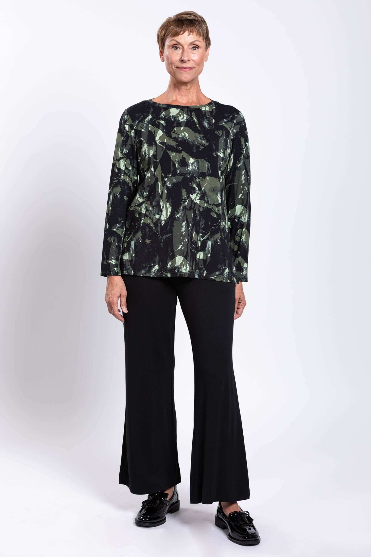 Front-on standing pose showing Margie boat neck top and flared black pants