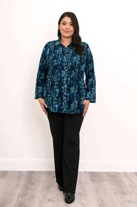 Woman in The Cindy blue floral smocked top, standing front view
