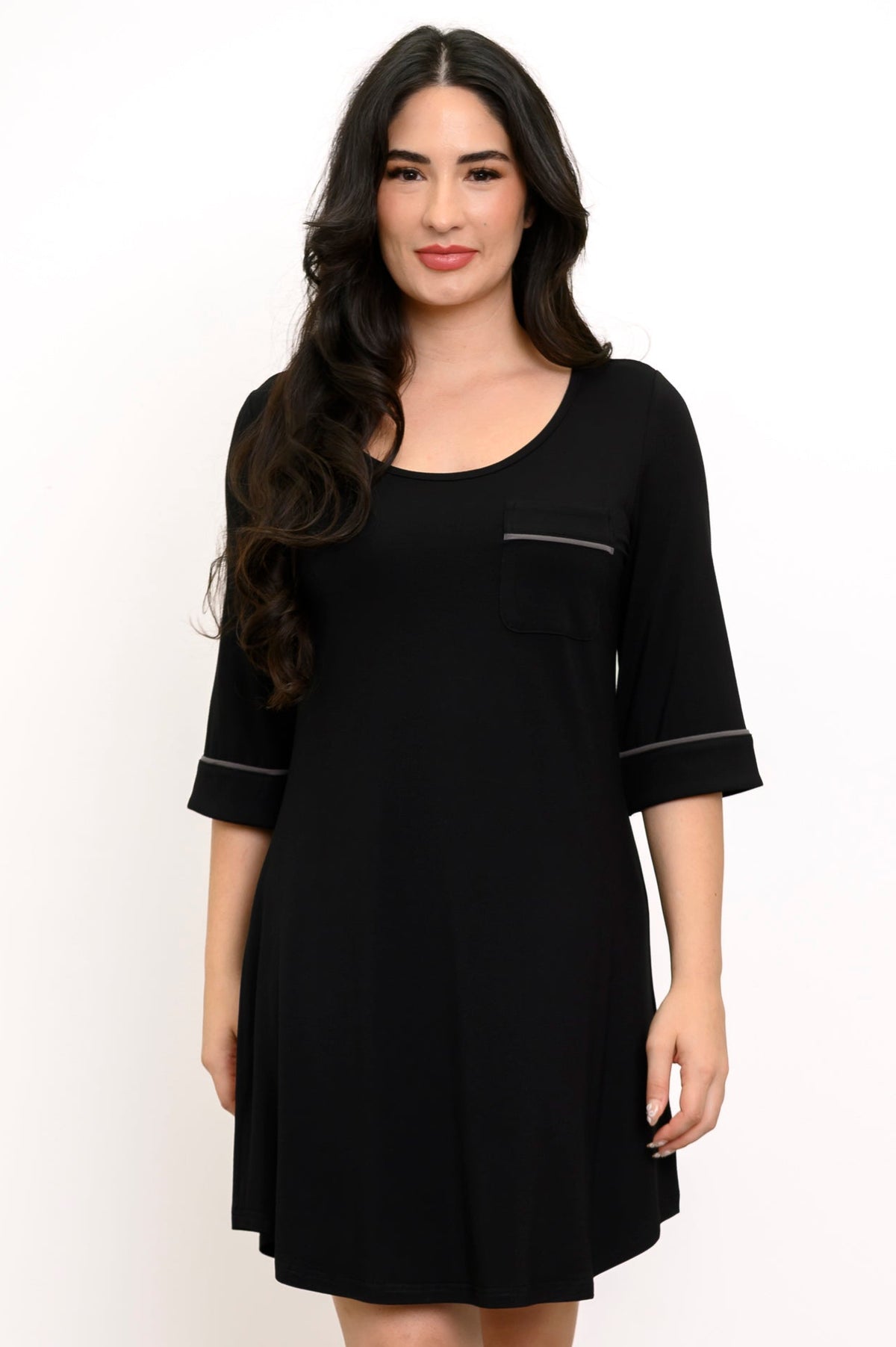 Front view of woman wearing a black dress with white trim on a white background