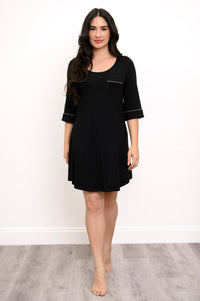 Full body view of woman wearing a black nightgown with white trim