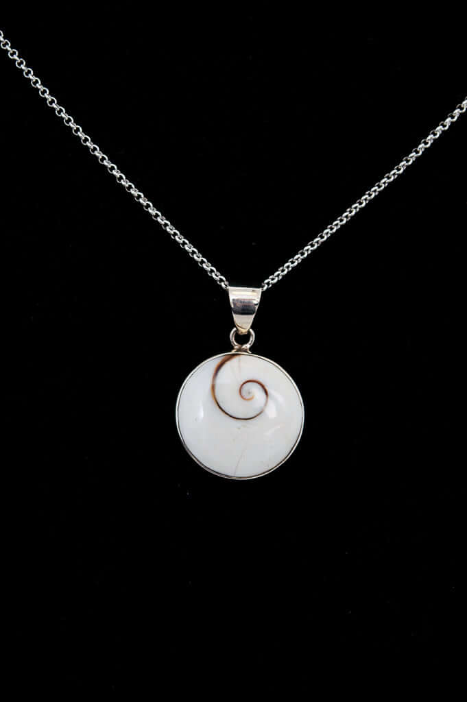 Close-up of a sterling silver necklace with round Shiva Eye pendant on black background