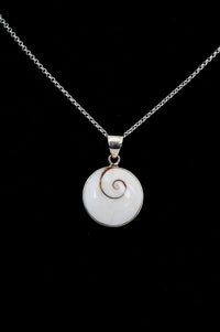 Close-up of a sterling silver necklace with round Shiva Eye pendant on black background