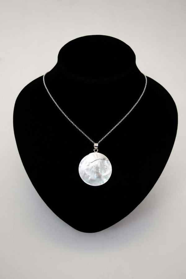 925 sterling silver necklace with round shell pendant displayed on a black bust stand