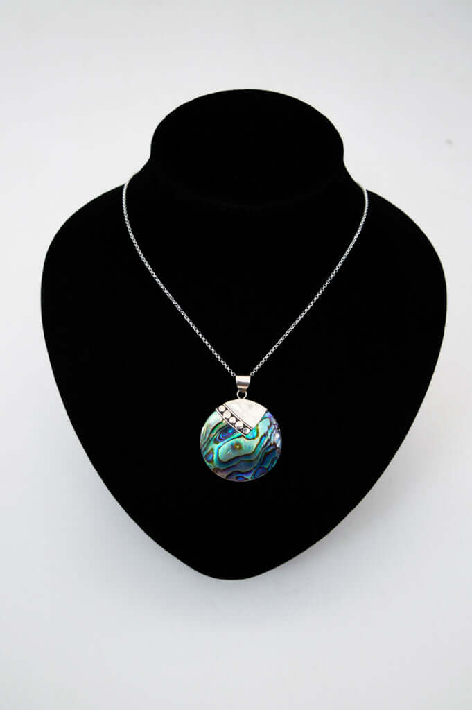 Sterling silver necklace with abalone pendant displayed on a black jewelry bust
