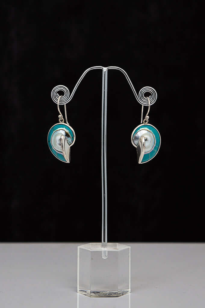A pair of 925 sterling silver spiral earrings with blue accents displayed on a stand