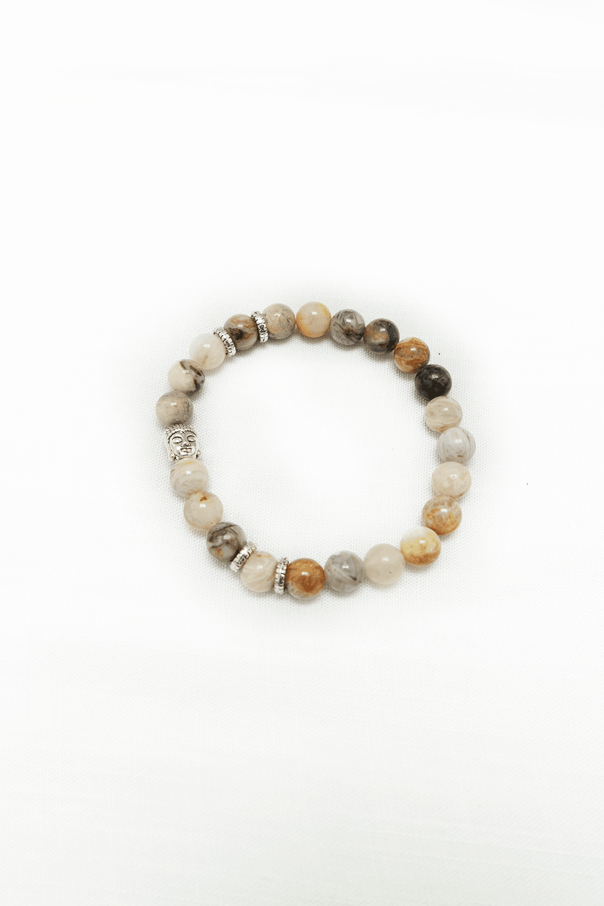 A round beaded bracelet with natural stone beads and decorative silver accents on a white background