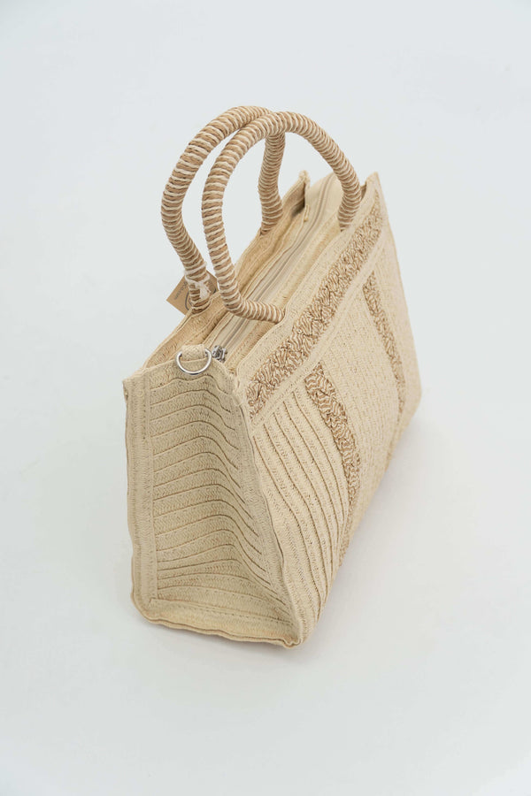 Angled view of a structured woven paper tote bag showing zip closure and handles