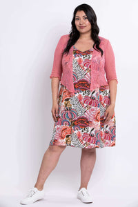 Model wearing a floral dress paired with a pink cardigan