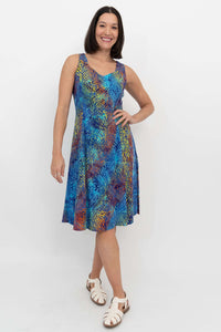 Woman wearing a sleeveless A-line dress with vibrant electric palm print, front view
