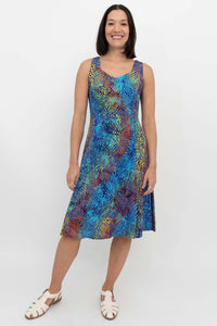 Front view of a woman in a colorful electric palm patterned sleeveless dress