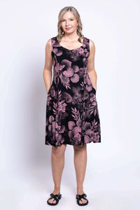 Woman wearing Sweet Sara dress with hands in pockets, pink botanica print